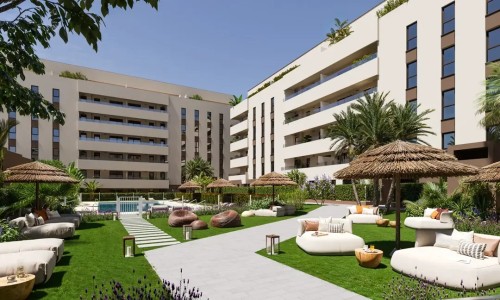 Espacios exteriores comunes de la urbanización privada Insur Iris. Diseño de paisajismo cuidado con palmeras, áreas de paseo y acceso a las instalaciones deportivas y sociales, ideal para la vida familiar en Sevilla.
